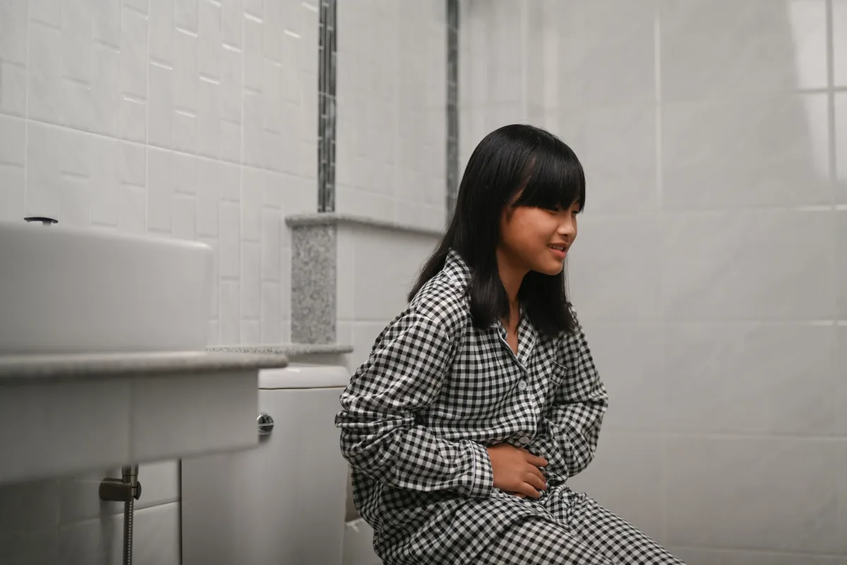 A seated person holding their abdomen