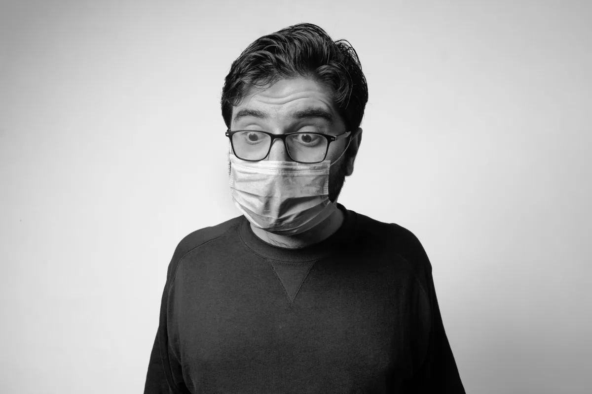 A person wearing glasses and a face mask